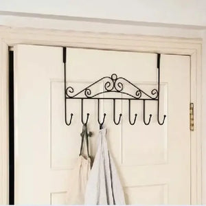 Decorative over-the-door hook rack with hooks on a white door.