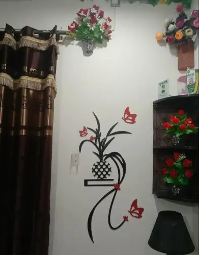 Decorative wall with floral arrangements and a wall decal of a plant and butterflies.