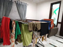 Room with clothes hanging on a rack and curtains in the background
