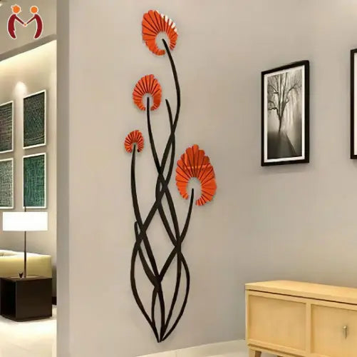 Decorative wall art with orange flowers and black branches on a wall in a room.