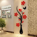 Decorative wall sticker of a black vase with red flowers on a wall.