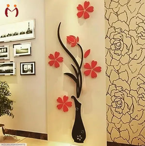 Decorative wall art with a black vase and red flowers on a beige wall.