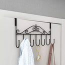 Decorative wall-mounted hook rack with hooks on a white door.