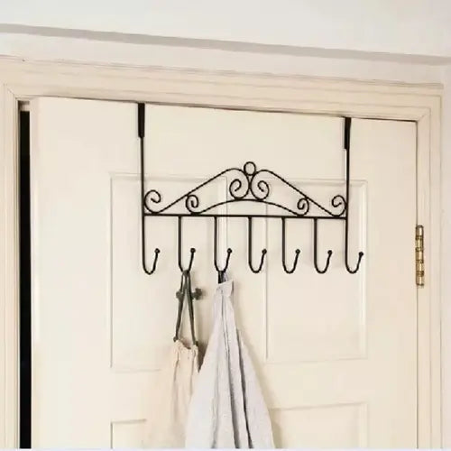 Decorative over-the-door hook rack with hooks on a white door.