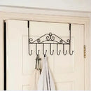 Decorative over-the-door hook rack with hooks on a white door.