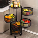 Black multi-tiered kitchen organizer with fruits and vegetables on a tiled floor.