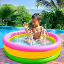 Child playing in a colorful inflatable pool with a tropical background